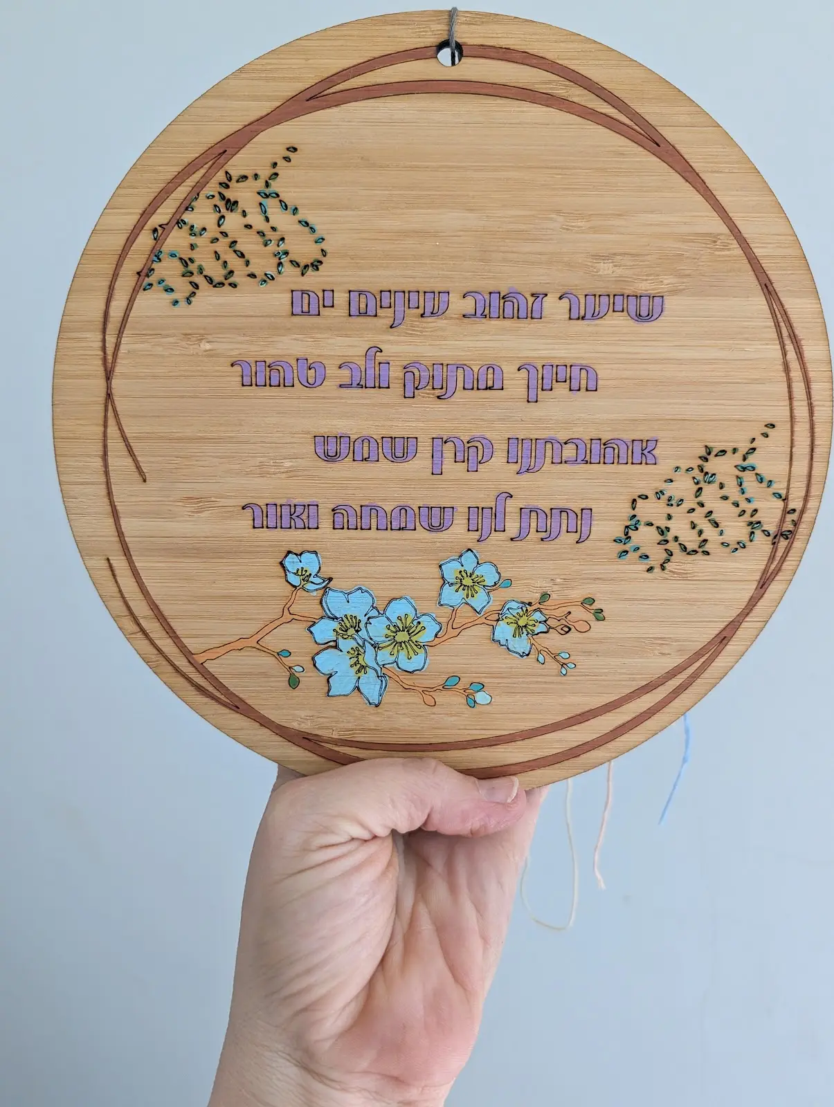 לוח עגול עם שיר ופרחים צבעוניים
